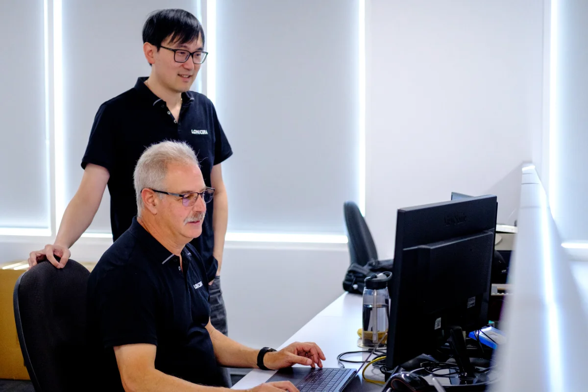 Perry and Danny working at desk by window
